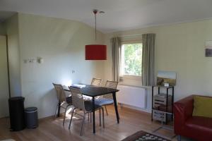a living room with a dining room table and chairs at Heitje 166 in Den Burg