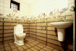 a bathroom with a toilet and a sink at Dean Dale Cottages in Thekkady +191 photos