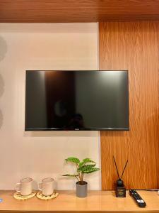Un televisor de pantalla plana colgado en una pared en Transient Room Near SM Lipa and LIMA PARK, en Inosloban