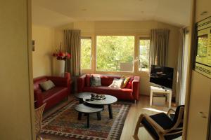 a living room with a red couch and a table at Heitje 166 in Den Burg
