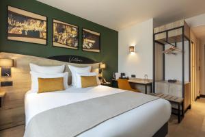 马尔萨克Hôtel OstOria Périgueux, BW Signature Collection的配有一张大床和一张书桌的酒店房间