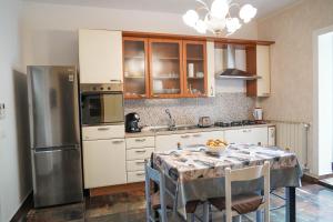 a kitchen with a table and a stainless steel refrigerator at Calabria is Home in Crotone