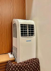 un aire acondicionado blanco sentado en una pared en Transient Room Near SM Lipa and LIMA PARK, en Inosloban 4 fotos más