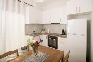 eine Küche mit einem Holztisch mit einer Blumenvase in der Unterkunft Ioulia in Kalamata