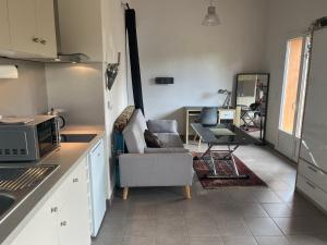 a kitchen with a couch and a chair in a room at Charmante petite maison provençale in Grasse