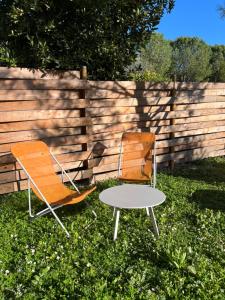 due sedie e un tavolo di fronte a una recinzione di Charmante petite maison provençale a Grasse