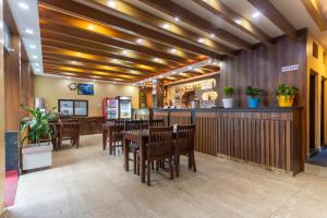 a restaurant with a bar with wooden tables and chairs at Hotel Airport Deepshree in Kathmandu