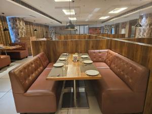 a dining room with a table and leather chairs at HOTEL SVM GRAND RAMANTHAPUR in Hyderabad