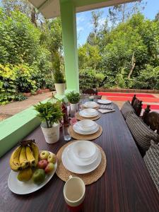 a wooden table with plates of fruit on it at KOORGI RETREAT- Coorg in Napoklu +50 photos