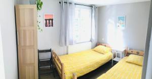 een slaapkamer met twee bedden en een raam bij Entre Mer et Montagnes in Céret