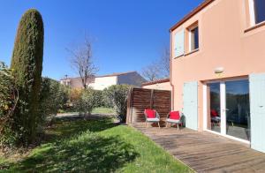 a wooden deck with two chairs and a house at Maison Les Demeures du Ventoux in Aubignan