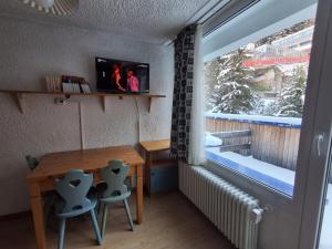 a small room with a wooden table and a window at Lo Gnomo Apartment in Marilleva