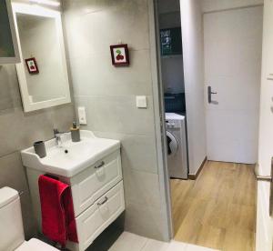 een badkamer met een wastafel, een toilet en een spiegel bij Entre Mer et Montagnes in Céret