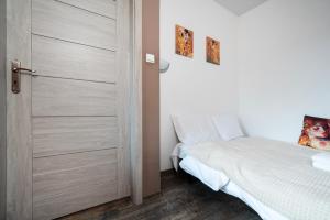 a bedroom with a door leading to a bed at Obywatelska Comfort Apartment by BookingHost in Łódź