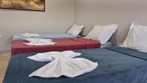 two beds with towels on them in a room at Suíte Harmonia 3 in Campo Grande