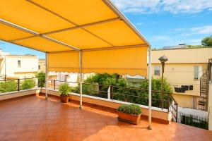 a large yellow canopy on a balcony with plants at A un passo dal cuore in Mesagne