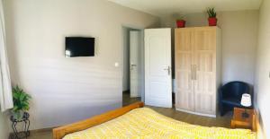 een slaapkamer met een bed en een tv aan de muur bij Entre Mer et Montagnes in Céret