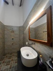 a bathroom with a white sink and a mirror at Villa Amore in Ahangama