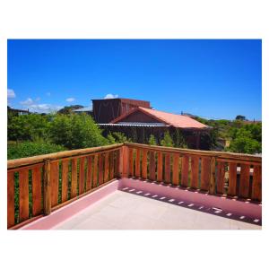 a wooden deck with a view of a house at Nao Tem Fim in Punta Del Diablo +109 photos