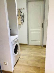 een wasruimte met een deur en een wasmachine bij Entre Mer et Montagnes in Céret