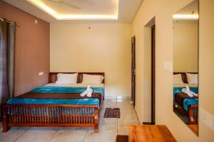 a small room with a bed and a table at Dean Dale Cottages in Thekkady