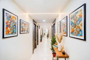 Un pasillo con cuadros en las paredes. en FabHotel Malva, en Ahmedabad