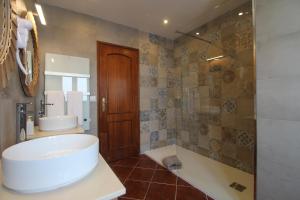 ein Badezimmer mit Badewanne, Waschbecken und Spiegel in der Unterkunft Apartamento Magnólia 80186 AL in Vila Nova de Milfontes