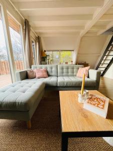 a living room with a couch and a table at La Cachette De Durbuy - Chalet 203 in Durbuy