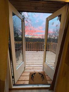 a view from the inside of a porch with sliding glass doors at La Cachette De Durbuy - Chalet 203 in Durbuy