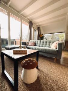 a living room with a couch and a table at La Cachette De Durbuy - Chalet 203 in Durbuy