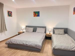 a bedroom with two beds and two lamps on tables at Jenny House in Sapareva Banya