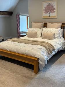 un grand lit avec un cadre en bois dans une chambre dans l'établissement The Cottage at Sychnant Farm, à Talgarth