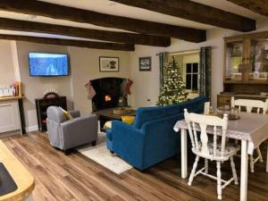 un salon avec un canapé bleu et un sapin de Noël dans l'établissement The Cottage at Sychnant Farm, à Talgarth