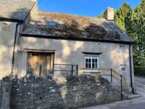 une ancienne maison en pierre avec un portail en face de celle-ci dans l'établissement The Cottage at Sychnant Farm, à Talgarth
