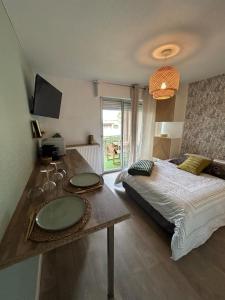 巴拉吕克莱班studio de la lagune piscine parking的一间卧室配有一张床和一张桌子及水槽 更多18张照片