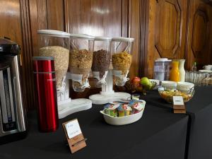Una mesa con recipientes de comida y otros alimentos. en Travels Hotel, en Osorno