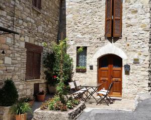 un tavolo e sedie di fronte a un edificio in pietra di Casa Maria ad Assisi