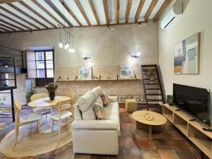 a living room with a couch and a tv at La Casona del Asno in Alcalá de Henares