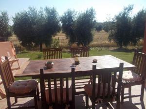 een houten tafel en stoelen op een terras bij Appartamento Girasole Seaside and Pool in La Caduta