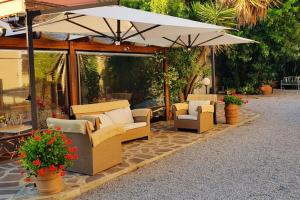 een groep stoelen en parasols op een terras bij Appartamento Lavanda Seaside and Pool in La Caduta