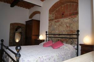 een slaapkamer met een bed met roze kussens erop bij Appartamento Lavanda Seaside and Pool in La Caduta