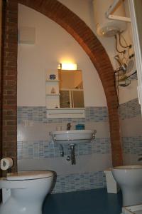 een badkamer met een wastafel en 2 toiletten bij Appartamento Lavanda Seaside and Pool in La Caduta +9 foto's