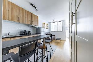 a kitchen with a counter and chairs in a room at Comfortable Apartment , Porte-Dorée District, Paris in Paris
