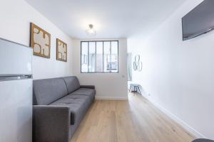 a living room with a couch and a television at Comfortable Apartment , Porte-Dorée District, Paris in Paris
