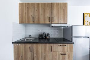 a kitchen with wooden cabinets and a stainless steel refrigerator at Comfortable Apartment , Porte-Dorée District, Paris in Paris +27 photos