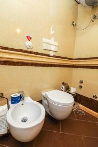 ein Badezimmer mit einer weißen Toilette und einem Waschbecken in der Unterkunft Hotel BRILANT ANTIK City Center in Tirana + 10 Fotos