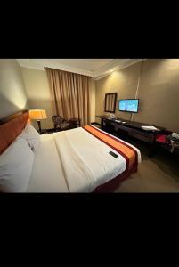 Ένα ή περισσότερα κρεβάτια σε δωμάτιο στο Grand Q Hotel Gorontalo