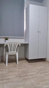 a white desk with a chair and a white cabinet at Suíte Harmonia 4 in Campo Grande