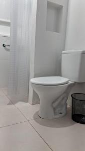 a white bathroom with a toilet and a shower at Suíte Harmonia 4 in Campo Grande