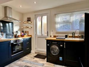 a kitchen with a washing machine in a kitchen at Jasmine Cottage Audlem in Audlem